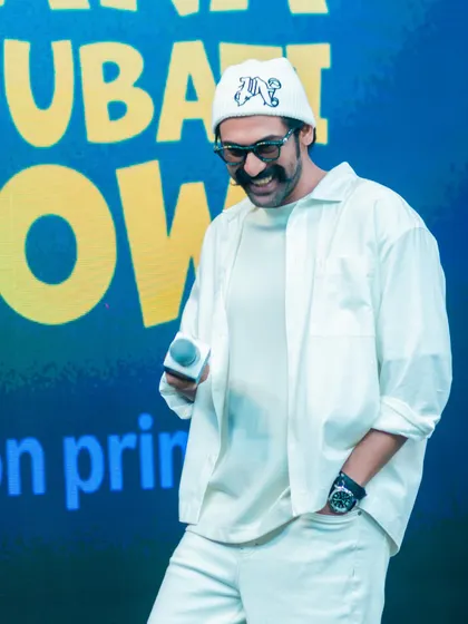 A candid moment on stage. Rana's all-white outfit looks fresh and modern under the stage lights.