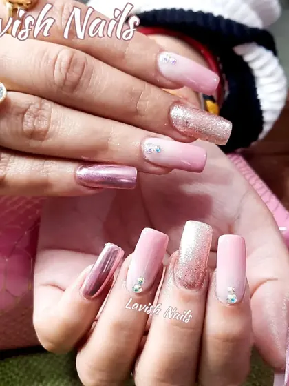 A trendy mix-and-match set with metallic pink chrome, pink ombré, full-coverage glitter, and scattered crystal accents on long square nails.