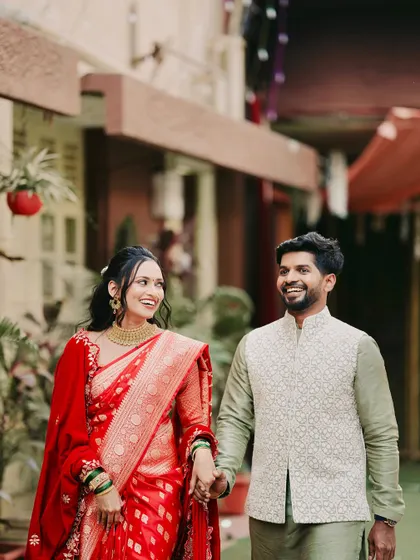 A happy moment captured. The bride and groom look perfect together. Her traditional red saree and gold jewellery are complemented by a fresh and natural makeup look.