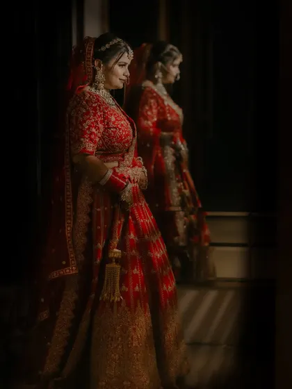 A moody and reflective bridal portrait, with the bride looking at her reflection in a mirror before the ceremony.
