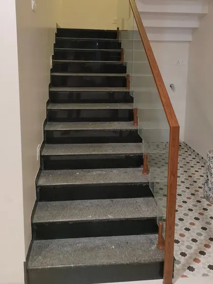 A simple yet elegant glass railing with a wooden handrail for an internal staircase. This is a practical and stylish solution that fits well in many contemporary homes.