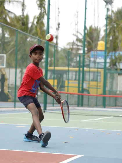 A young player in our red ball program makes contact with the ball. Using softer, slower balls on smaller courts allows our youngest athletes to learn proper swing mechanics and enjoy rallying from their very first lesson.
