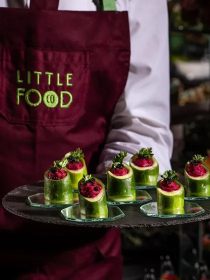 Our Beetroot and Feta Mousse served in hollowed-out cucumber cups. This is a fresh, vibrant, and healthy canapé, beautifully presented on a slate tray by our server in our signature apron.