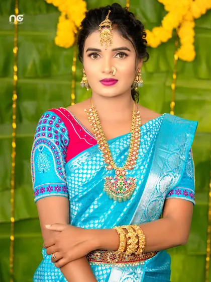 A model in a bright blue saree, styled with a Navratna-style haram, showcasing a mix of colorful stones.