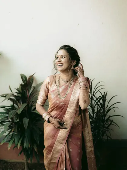A candid shot of a bride in a beautiful pink silk saree, her laughter echoing her happiness.