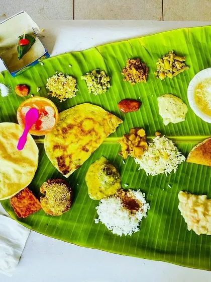 A beautiful top-down view of a traditional oota. You can see the perfect placement of salt, pickle, palyas, kosambari, holige, and rice, all ready for the guests to enjoy.