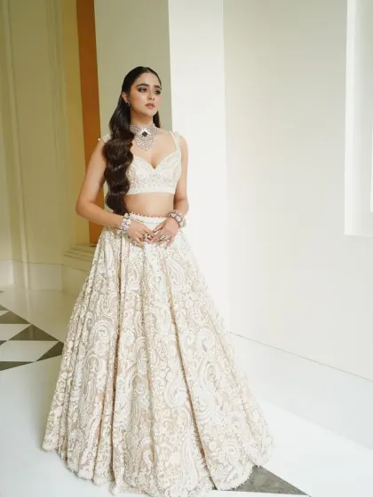 This shot showcases the beautiful A-line silhouette of the lehenga and the bride's poised and graceful stance.