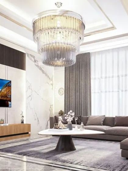 A luxurious living room from a 3BHK villa in Pune. The grand chandelier, plush sofa, and marble-clad TV wall create an atmosphere of modern opulence.