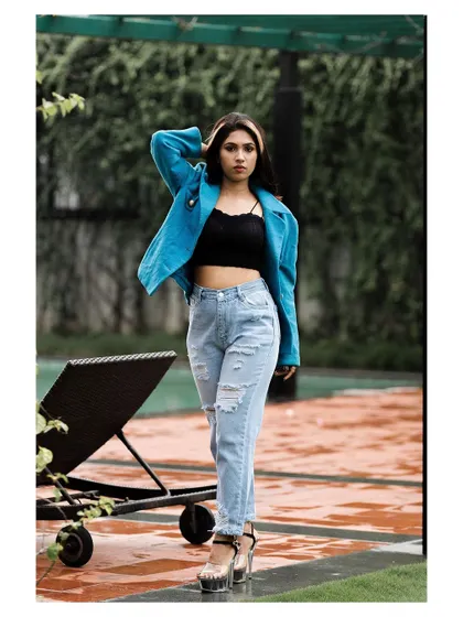 An outdoor fashion shot with a cool, urban vibe. The model's confident stance and stylish outfit create a modern and edgy look.