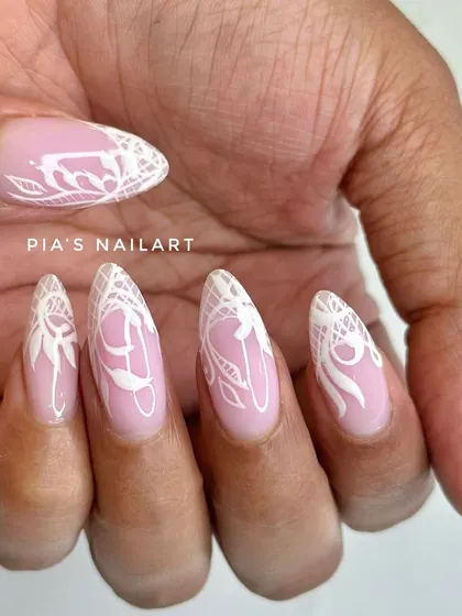 A closer view of the detailed white lace nail art, showing the fine lines and patterns that make this design so special.