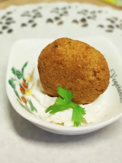A close-up of a single mutton cutlet, showcasing its texture. It's a hearty and flavorful bite, perfect as a passed appetizer.
