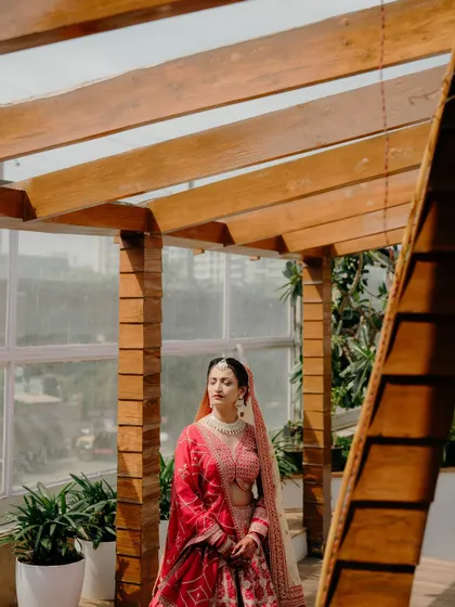 A bride stands in a moment of quiet thought on a beautiful wooden terrace before her wedding.