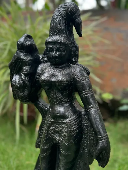 A full-length view of our black granite Madurai Meenakshi statue, showcasing the goddess with her traditional parrot companion.