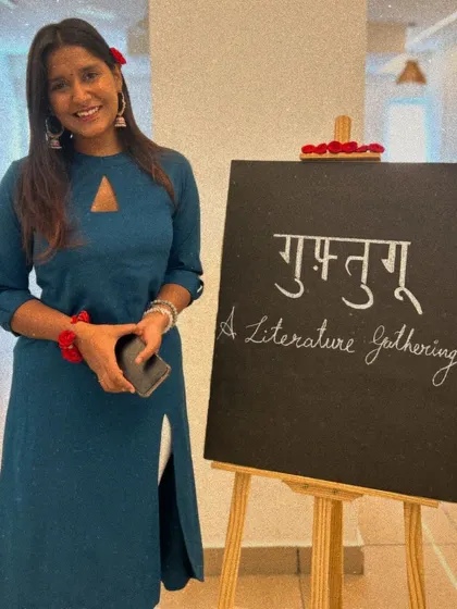 A participant poses happily next to the event signage.