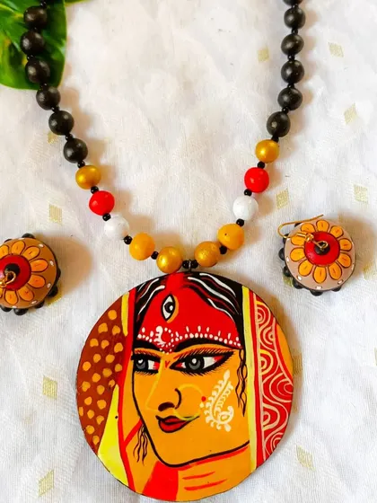 A close-up of the full-face Durga pendant, highlighting the intricate 'alpona' (rangoli) details on her face. This level of detail is a hallmark of my premium hand-painted range.