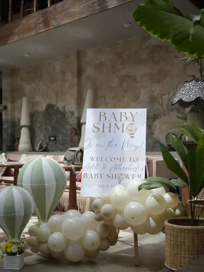 The welcome setup for the 'Baby Shmo' shower, with a personalized sign, balloon clouds, and miniature hot air balloons to set the theme.