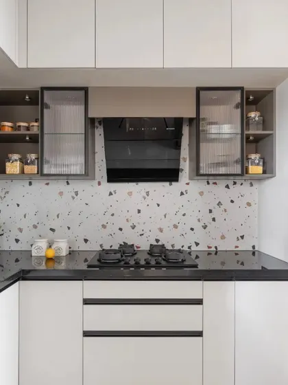 A wider view of the terrazzo backsplash kitchen, showcasing the ample storage provided by the floor-to-ceiling white cabinets and the sleek, integrated chimney.