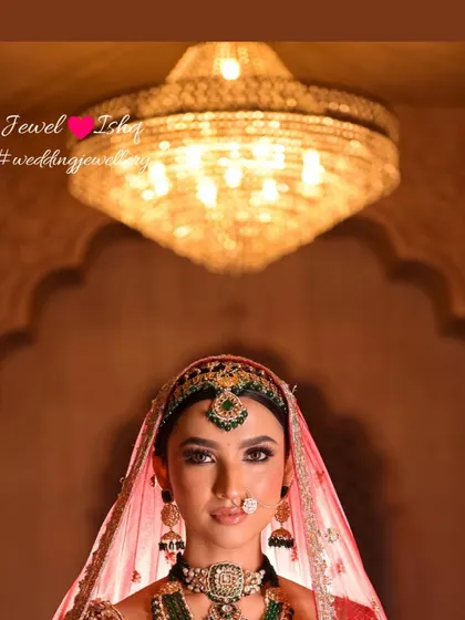 This artistic shot places the bride under a grand chandelier, enhancing the royal feel of her look. The focus is on her confident expression and the stunning bridal jewellery.