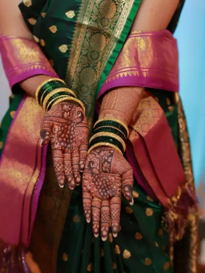 The bride showcasing her beautiful palm-side mehndi. The dark, rich color is the result of using high-quality, natural henna.