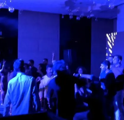 The party is still going strong, with blue lighting and a packed dance floor.
