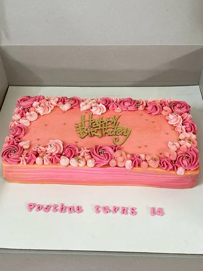 A beautiful rectangular red velvet cake decorated with an ombre of pink floral buttercream piping. Perfect for a large gathering.