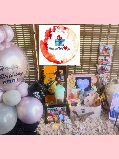 A fantastic 16th birthday setup with a K-pop (BTS) theme. It includes a large balloon display, a suitcase hamper filled with goodies, and personalized photos.