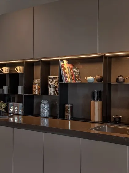 A close-up of the open shelving system. This feature breaks up the solid cabinetry and offers a practical spot for frequently used items, cookbooks, and decor.
