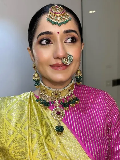 My beautiful Gujarati bride Archi, embracing simplicity and color. Her look features a vibrant pink and lime green saree, complemented by glowing skin and softly defined eyes.