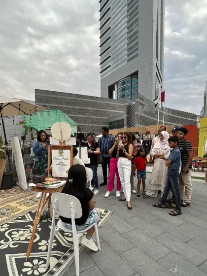 The crowd gathers! A shot of my booth in Dubai, with a curious audience watching the live art unfold.