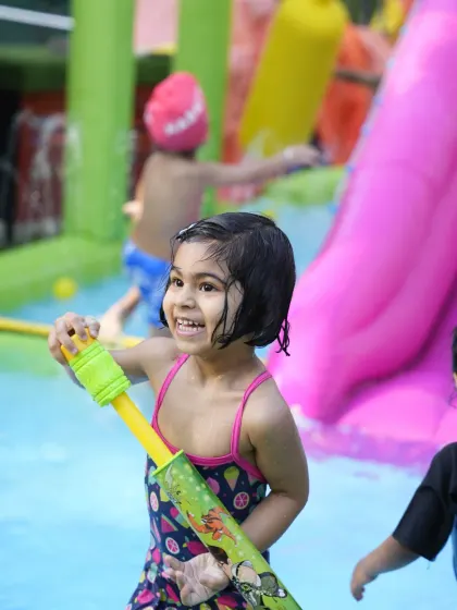 Pure joy at our splash pool party. A guest has a blast with a water gun, enjoying the fun and games we organize for our summer events.