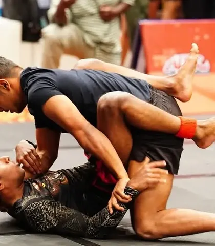 Grappling for control in a competitive BJJ match. Our training emphasizes resilience and adaptability, teaching fighters to stay hungry and humble on the path to greatness.
