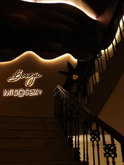 The stylish entrance to the 'Bougie Miso Sexy' lounge, capturing the venue's chic ambiance with its neon sign and elegant staircase.