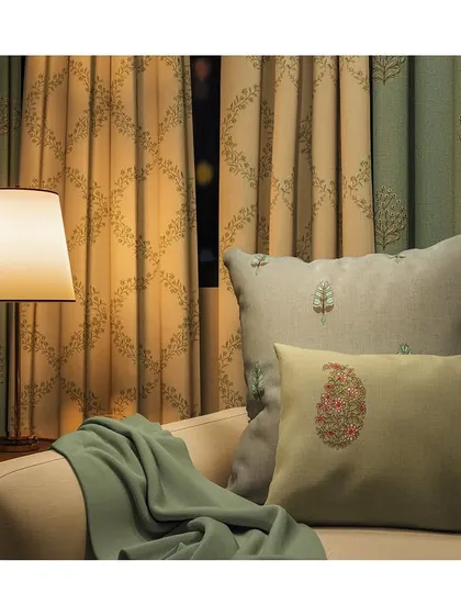 The 'Hues' collection features fabrics with timeless needlework, delicate paisleys, and elegant lattices in soft pastels. These threaded drapes and matching cushions create a cozy, elegant, and harmonious living space.