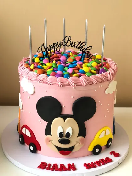 Another angle of the gem-topped Mickey Mouse cake, showing the little car details and cheerful design.