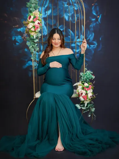 My studio is equipped with unique props like this floral birdcage swing to create elegant and whimsical maternity photos. This portrait in a stunning teal gown highlights the serene beauty of pregnancy.