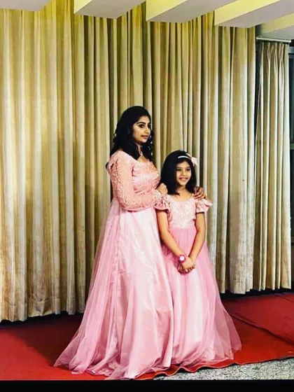 This mother and daughter look lovely in their matching light pink gowns. I used a soft net fabric and added subtle embroidery for an elegant look.