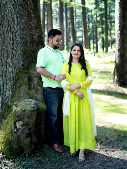 A pre-wedding portrait in a lush green forest, showing the couple in casual attire. This highlights the versatility of mountain shoots, from formal to relaxed.