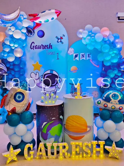 An adorable astronaut theme for Gauresh's first birthday. The decor features cute, cartoonish space elements, planet-themed pedestals, and a friendly astronaut ready for liftoff.