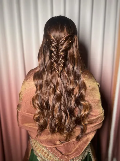 Another view of the intricate hairstyle. The fishtail braid with pearls is a modern and elegant choice.