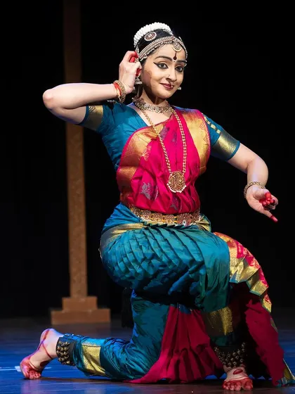 A kneeling pose from the Kanasu festival, combining grace with a strong, grounded posture.