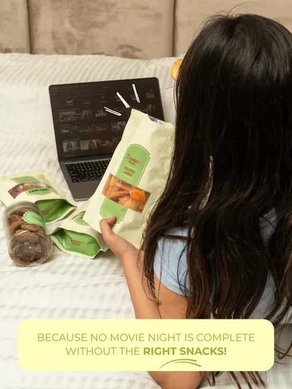 No movie night is complete without the right snacks! A girl enjoys a bag of my wholesome treats while binge-watching, making it a perfect, guilt-free evening.