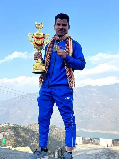Coach Rahul Singh overlooking the mountains of Tehri Garhwal with his trophy and gold medal. A victory that feels on top of the world.