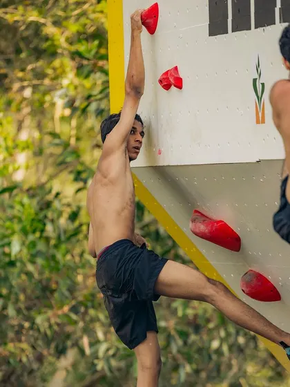 A climber pauses mid route to read the sequence of holds ahead. This mental aspect of route reading is just as important as physical strength in climbing.