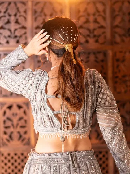 The hairstyle is key. This elegant ponytail with a hair accessory perfectly complements the modern vibe of the lehenga.