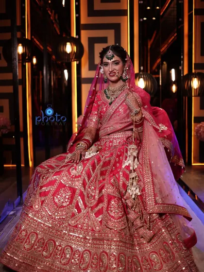 A regal bridal portrait with the bride seated, allowing her magnificent lehenga to be displayed in its full glory.