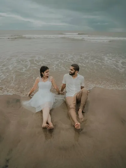 Sitting together as the waves wash over their feet. This peaceful pre-wedding photo of Pragati and Swapnil captures a moment of shared serenity on the beach.