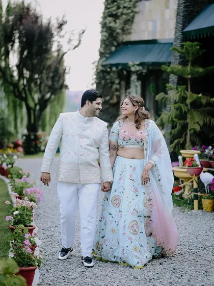 A happy walking shot of the couple in the beautiful gardens of the Shervani Hilltop resort.