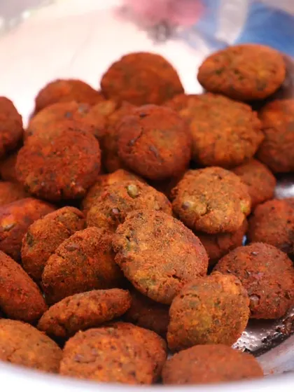 A bowl of spicy vegetable kebabs, seasoned with a red masala mix.