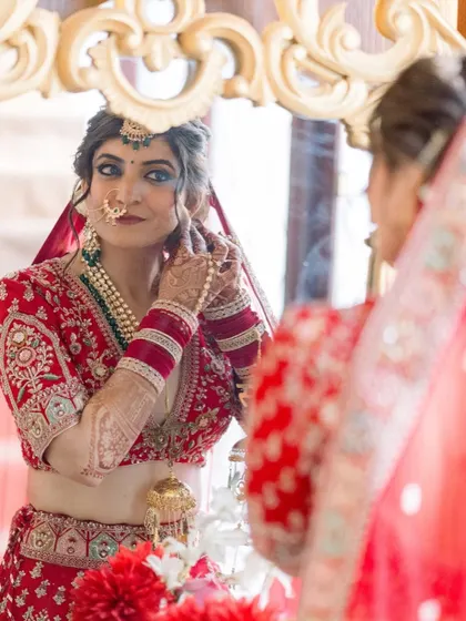 A classic getting ready shot. Divya checking her final look in the mirror, with her soft glam makeup and messy bun hairstyle.
