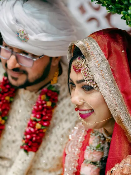A candid shot of the bride and groom, capturing a natural moment of happiness during their wedding festivities.